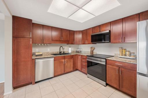 Spacious kitchen featuring rich wood cabinetry, granite countertops, stainless steel appliances, and abundant storage.