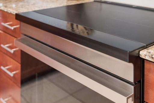 Modern slide-in induction range with a smooth glass cooktop and contemporary stainless steel detailing.