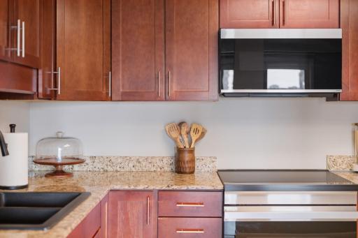 Updated kitchen appliances complement the warm cabinetry and granite countertops.