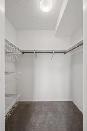 Fantastic walk-in closet features ample hanging space and built-in wire shelving for effortless organization.
