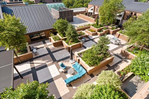 The expansive resident courtyard features lush gardens, multiple seating areas, and inviting spaces to gather or unwind.