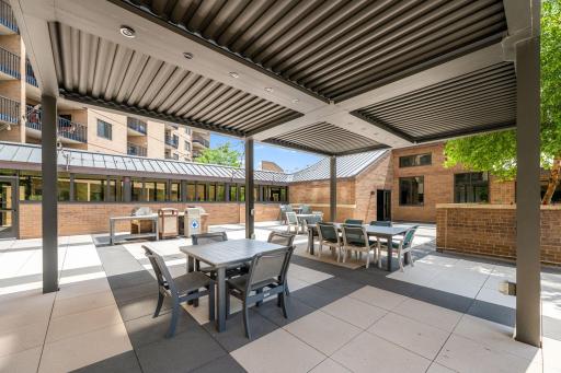 Covered outdoor dining area with seating, grills, and shaded gathering space.