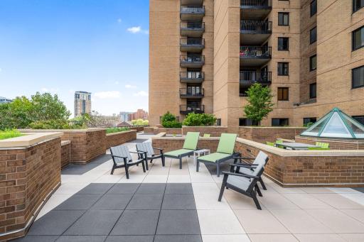Spacious common patio with multiple seating areas and garden-style landscaping.