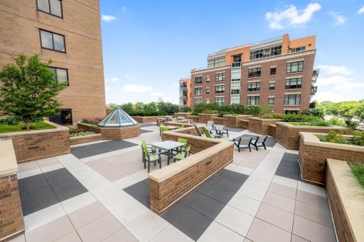 Beautiful outdoor plaza with landscaped planters, seating areas, and city views.