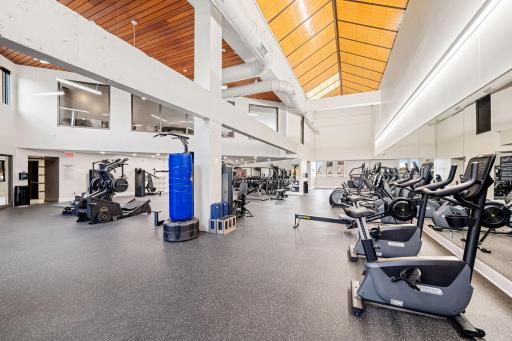 Expansive fitness center with cardio equipment, strength machines, and soaring ceilings.