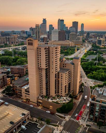 The Falls & Pinnacle rises above the riverfront neighborhood with Downtown Minneapolis creating a stunning sunset backdrop.