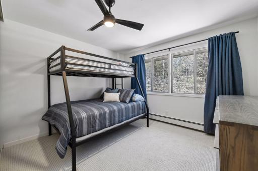 The guest bedroom features large windows that fill the space with natural light.