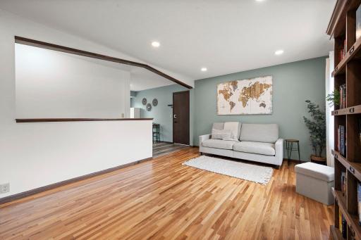 Sun-filled living room with gleaming hardwood floors & recessed lighting