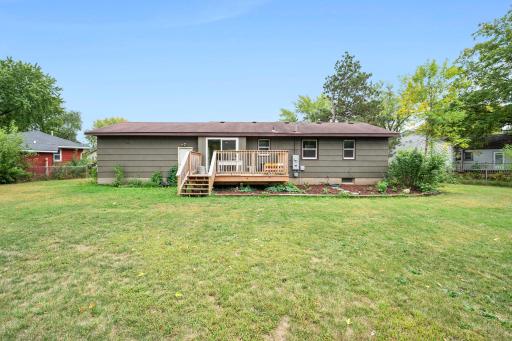 Back of the home with spacious deck & perennial garden beds