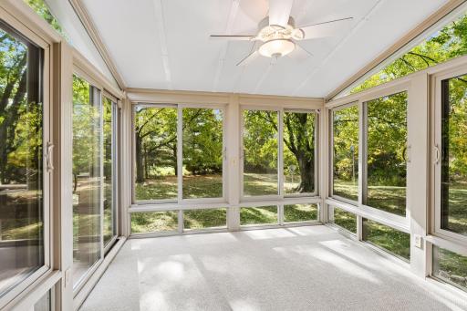 A delightful extension of the main living space! The three-season porch offers a wonderful place to relax, unwind, and enjoy views of the beautifully wooded backyard.