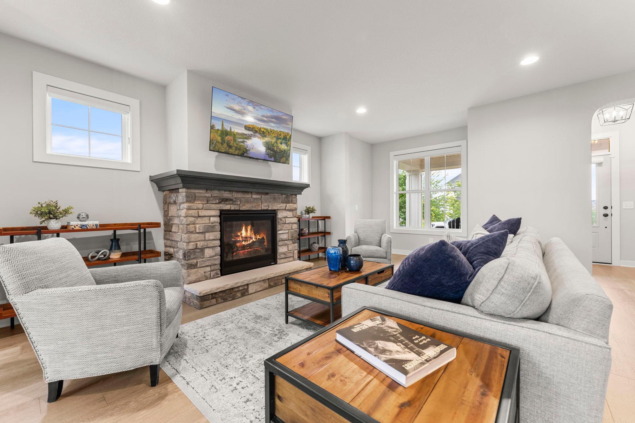 The living room is filled with natural light and is the perfect place to cozy up to the stone gas fireplace.