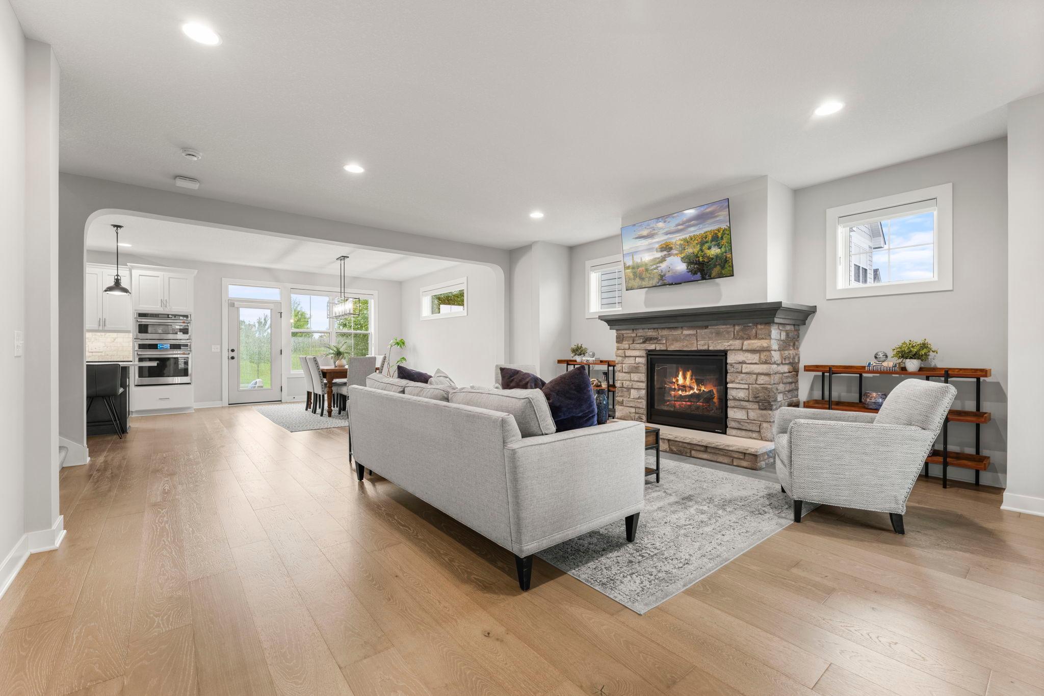 The living room, dining room, kitchen and foyer feature beautiful luxury vinyl tile floors and are filled with light from recessed lighting, lovely light fixtures and large windows.