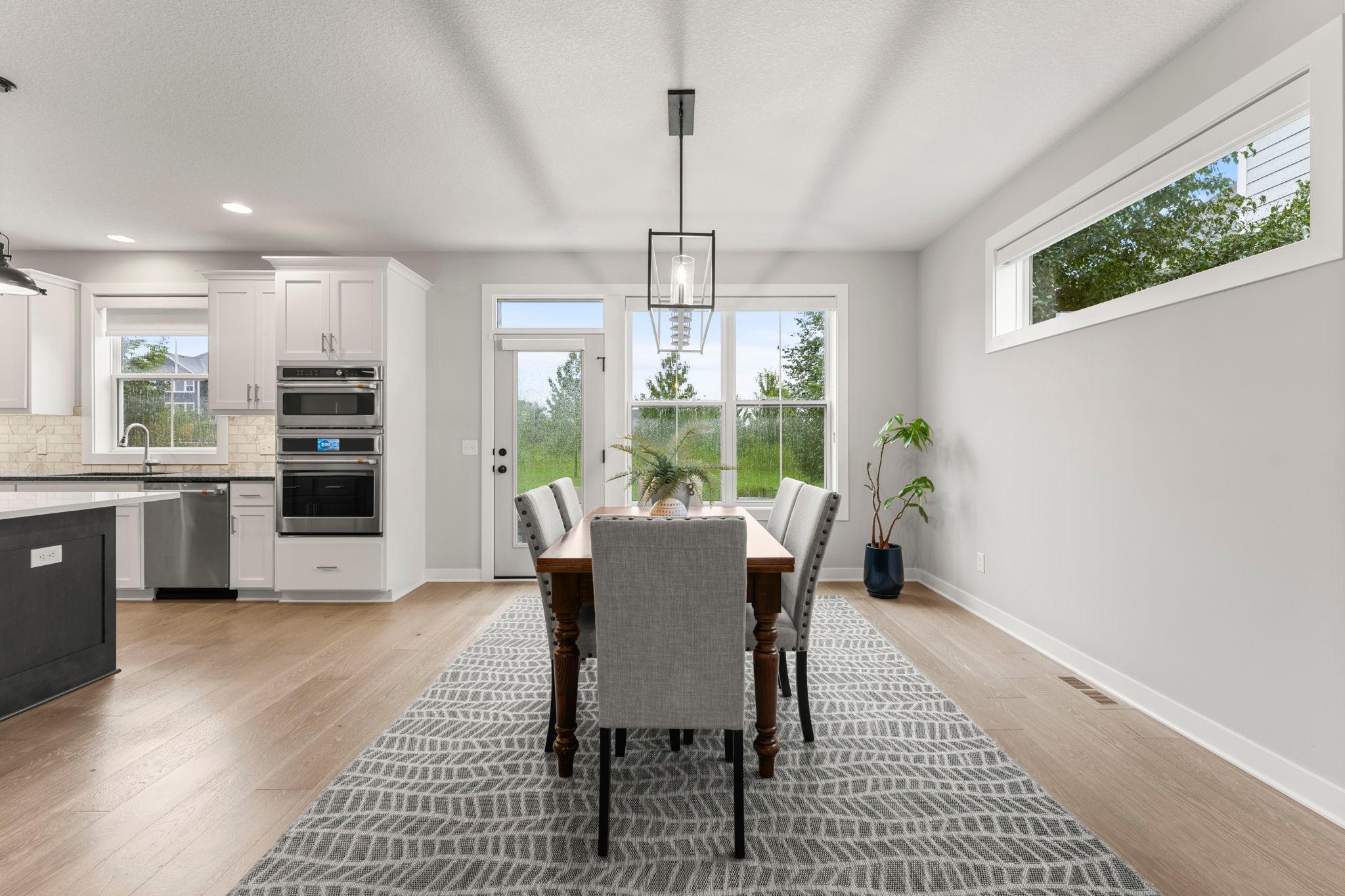 The informal dining room is filled with light from the wall of windows and the door to the backyard and paver patio.
