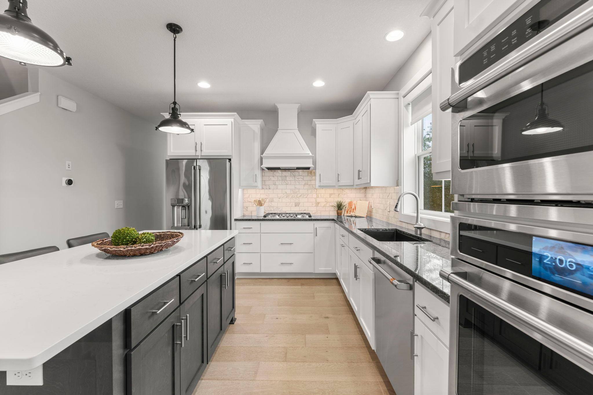 The kitchen is a chef's delight. It features stainless steel appliances, including a 5-burner gas stove, a wall oven with a microwave & convection oven, a dishwasher, & a refrigerator. It also includes a deep sink with disposal & a window.