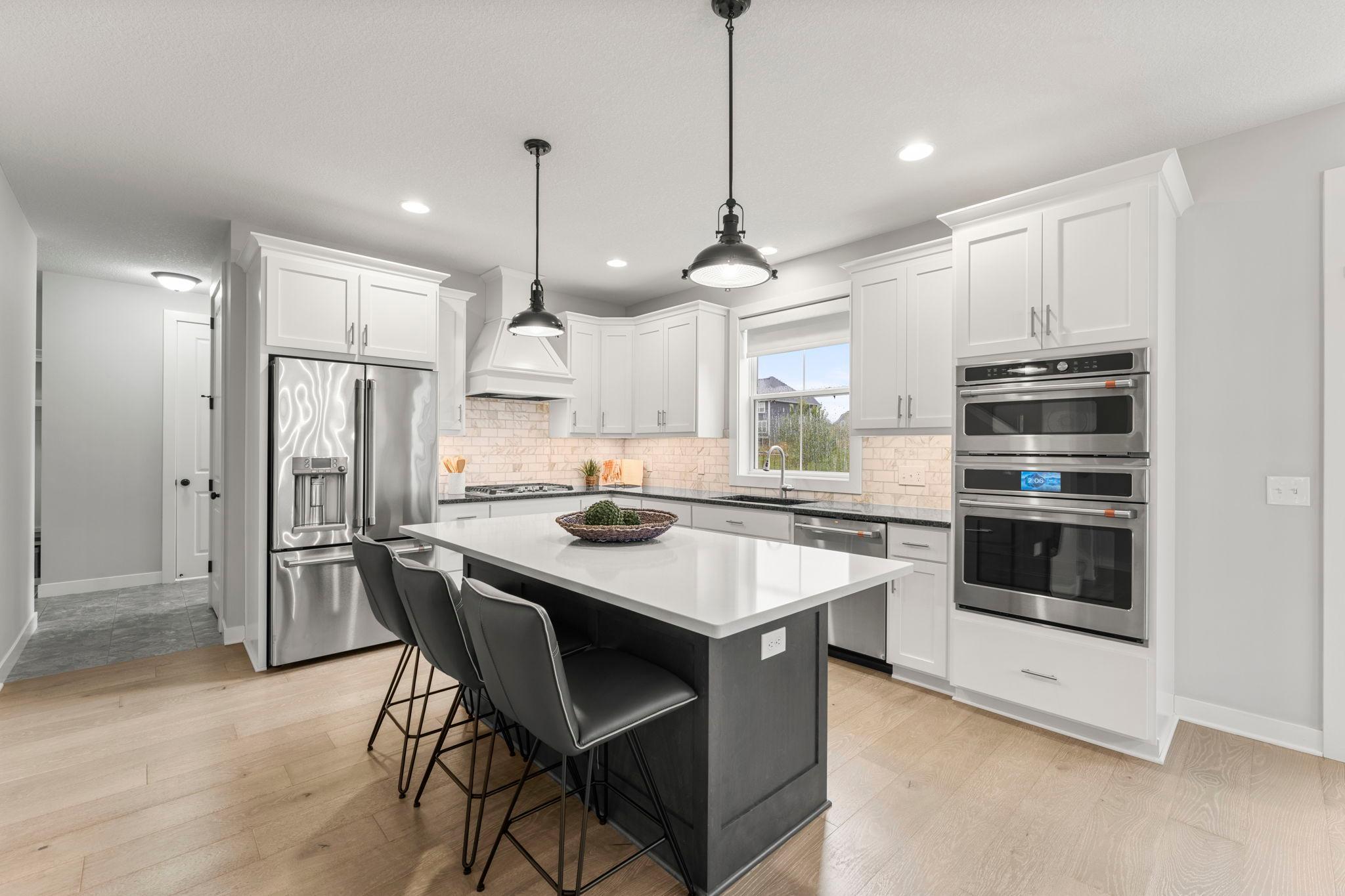 At the heart of the main level, the kitchen offers a generous island, abundant storage, and an easy connection to the dining and living spaces.
