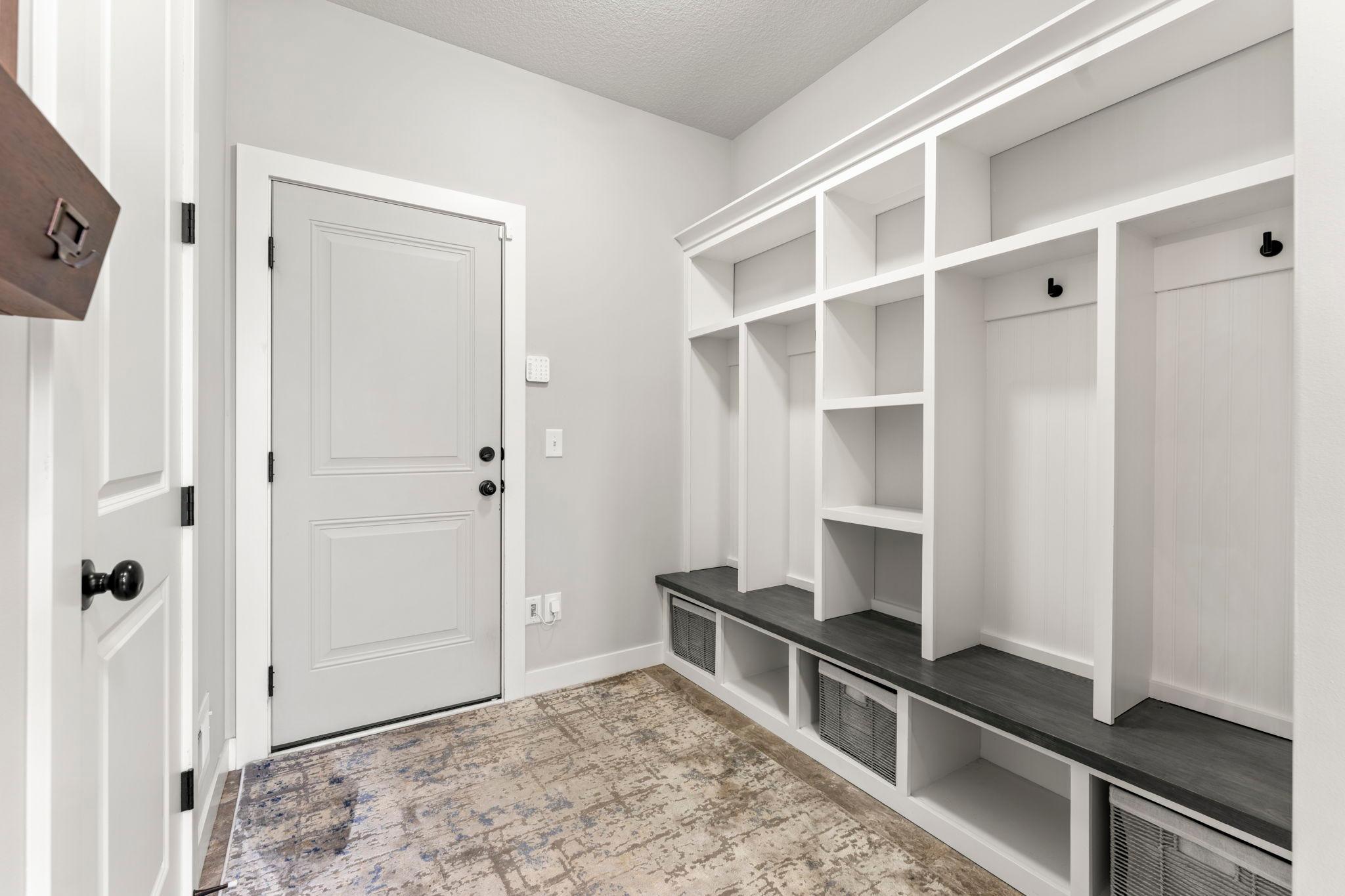 The mudroom off the garage service door features built-in lockers and cubbies (2025), ceramic tile floors, and a large walk-in closet.