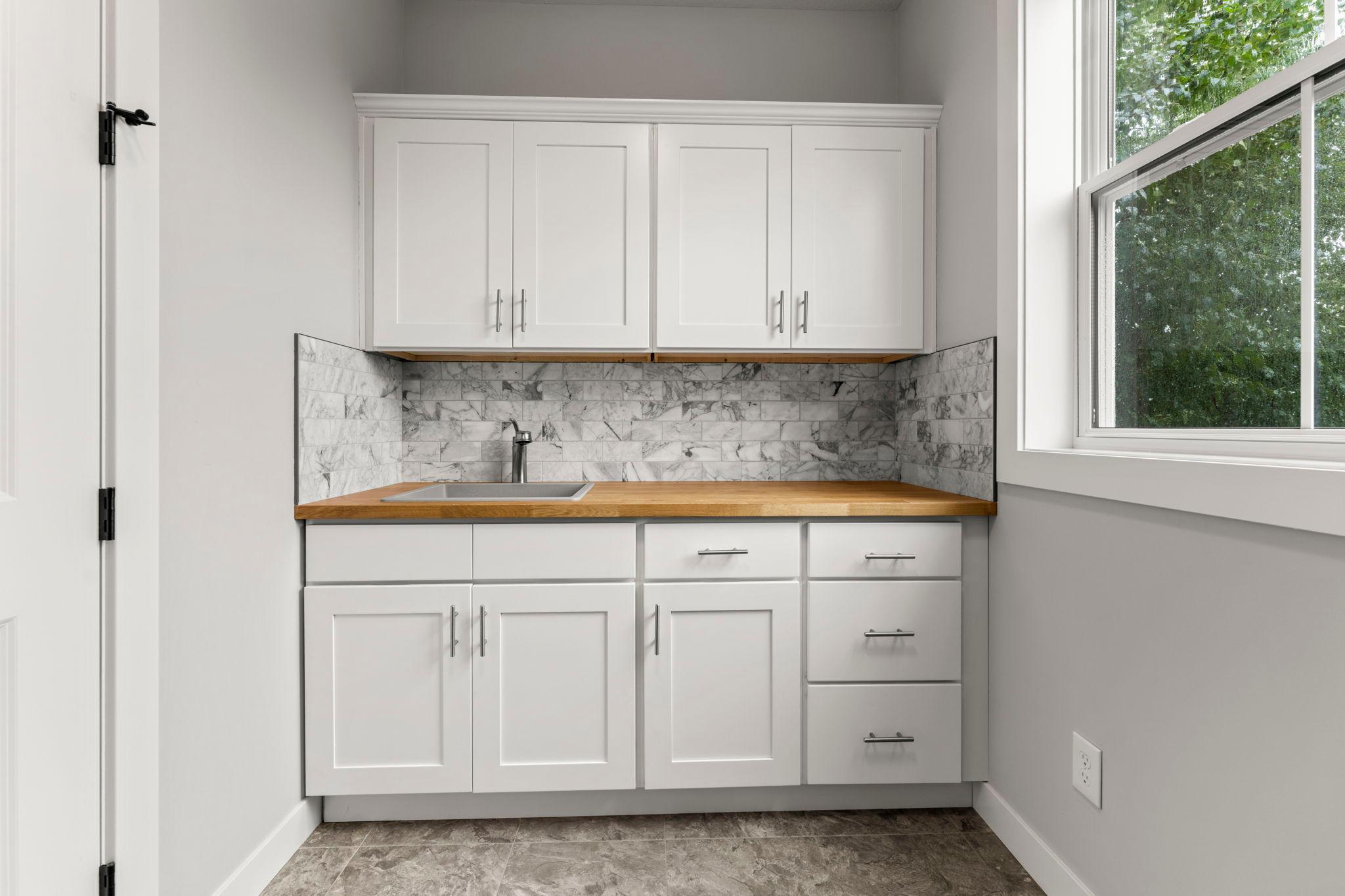 The utility sink, cabinets, a tile backsplash, and a folding counter were added in 2022.