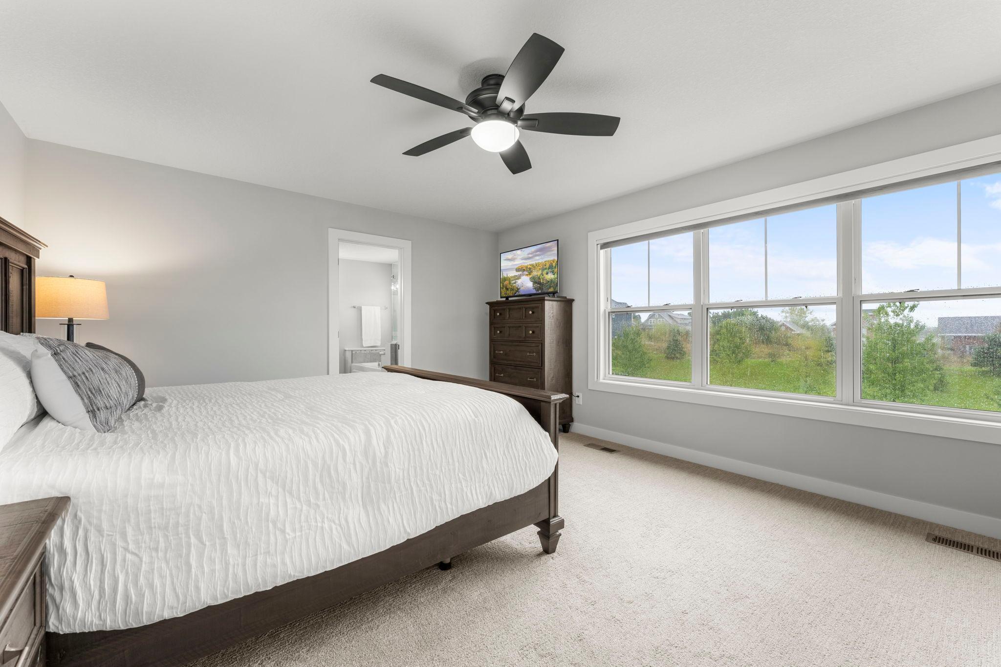 A wall of windows fills the primary suite with natural light, creating a bright, restful retreat at the end of the day.