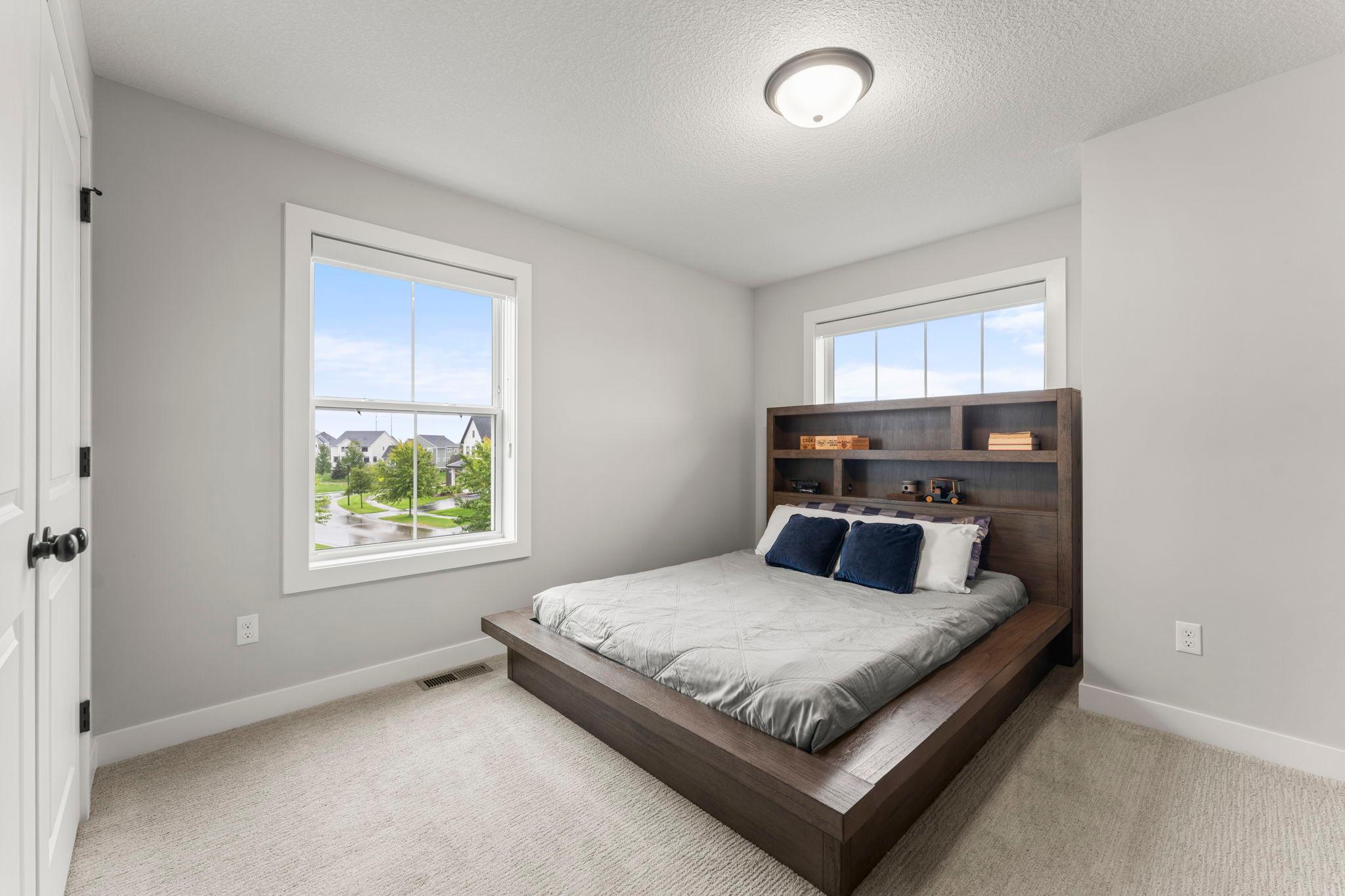 Bedroom three on the upper level includes two windows and a large closet with French doors.