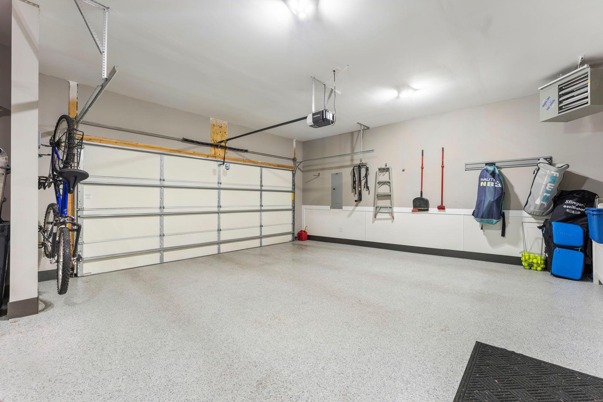 The heated, insulated 3-car garage features epoxy floors (2022), a 9 ft.+ ceiling, a pull-down electrical cord and LiftMaster garage door openers.