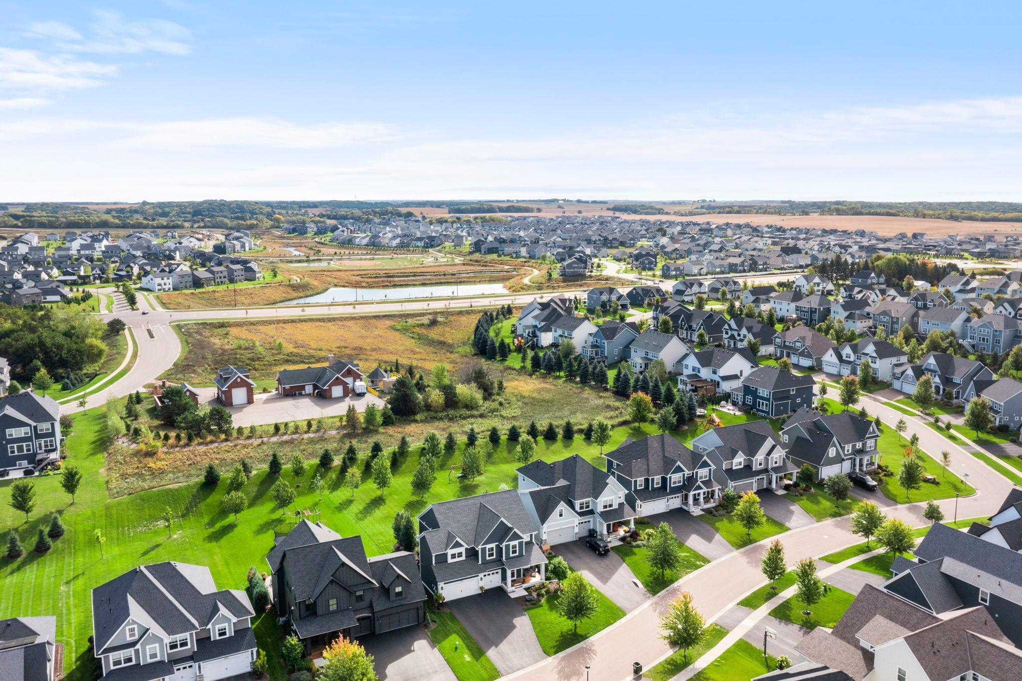 This aerial shows the rear privacy berm and open space beyond the backyard, with no homes directly behind the property.