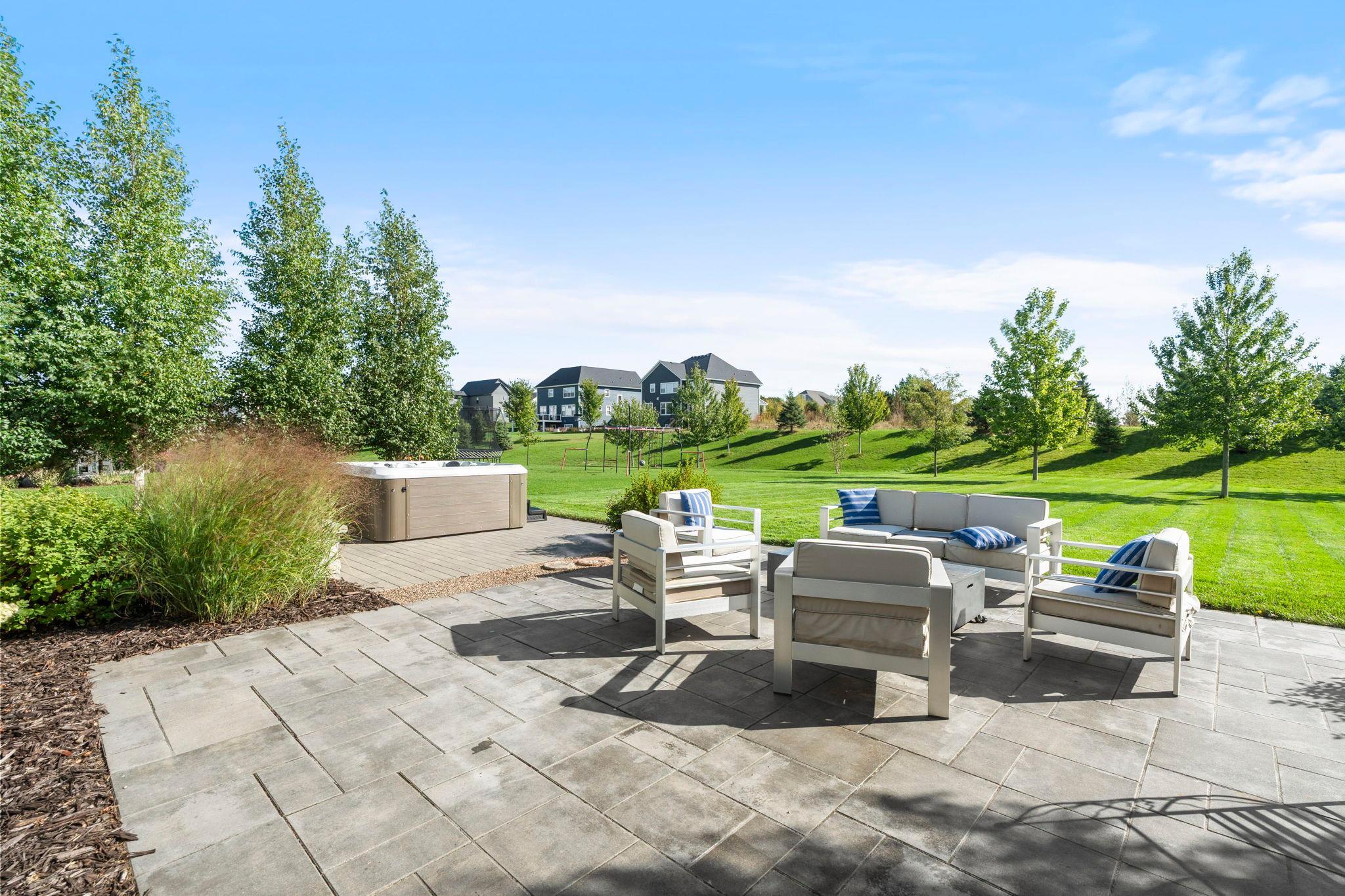 The large paver patio creates generous outdoor living space and includes the 2025 hot tub.