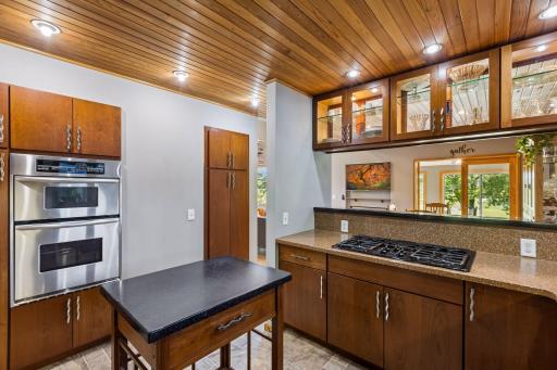 Spacious kitchen showcasing extensive cabinetry, stainless steel refrigerator, built-in double wall ovens, and a versatile center island with additional storage.