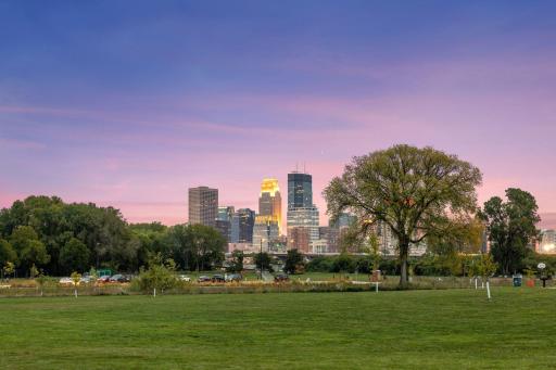 Enjoy a rare urban backdrop with beautiful Minneapolis skyline views beyond the surrounding trees and open green space.