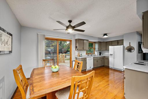 The dining area walks out to a brand-new deck overlooking a fully enclosed, 6-foot privacy-fenced backyard with a patio, storage shed, and two access gates