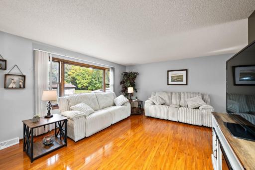 Open main floor layout with a bright living room with gleaming hardwood floors and an updated kitchen!