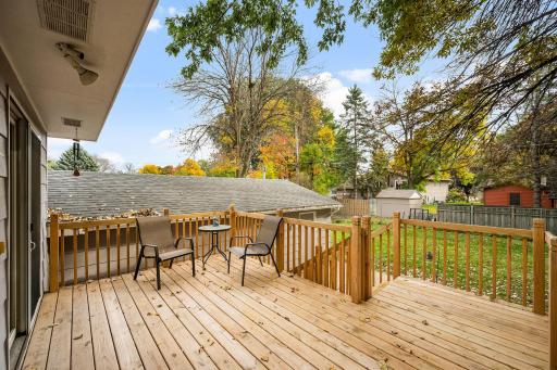 Brand-new deck overlooking a fully enclosed, 6-foot privacy-fenced backyard with a patio, storage shed, and two access gates.