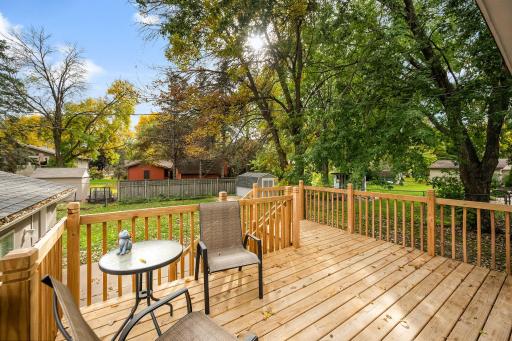 Brand-new deck overlooking a fully enclosed, 6-foot privacy-fenced backyard with a patio, storage shed, and two access gates.