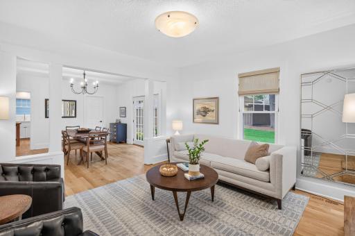 Light-filled living room with white oak floors and seamless flow to the dining room.