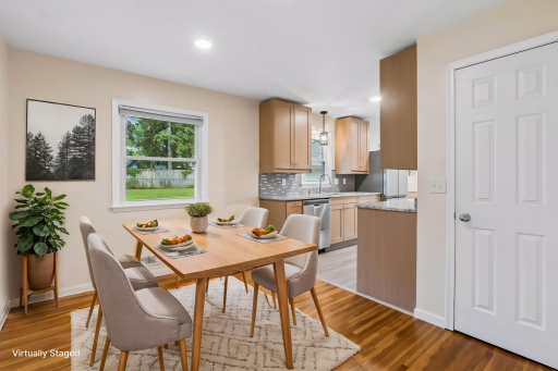Light-filled informal dining room features original hardwood floors, recessed lighting, views of the backyard, and easy access to the pantry—perfect for everyday meals and casual gatherings. Virtually staged.