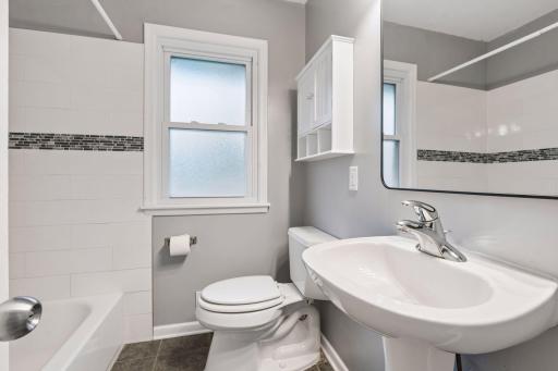 The main-floor bathroom offers timeless appeal with classic ceramic tile flooring and a ceramic tile tub/shower surround.