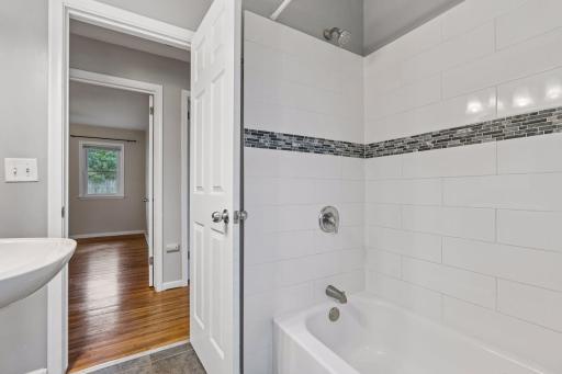 The main-floor bathroom offers timeless appeal with classic ceramic tile flooring and a ceramic tile tub/shower surround.