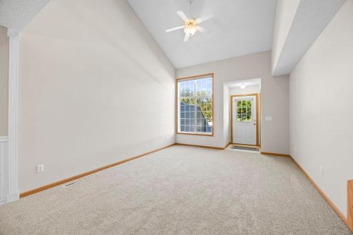 As you enter, you are greeted by a spacious living room featuring impressive 18-foot vaulted ceilings, a skylight, and a large front-facing picture window that fills the space with abundant natural light.