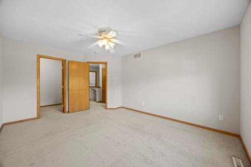 The upper level features two bedrooms, including a spacious primary bedroom with carpeting, ceiling fan, large front-facing window, and an impressive 8x7 walk-in closet with wire shelving.