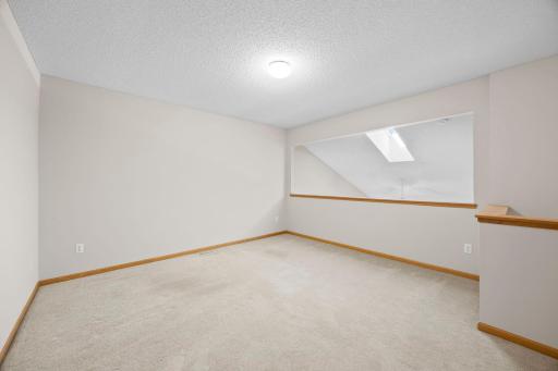 The loft features carpeting, closet space, and a railing overlooking the living room below.