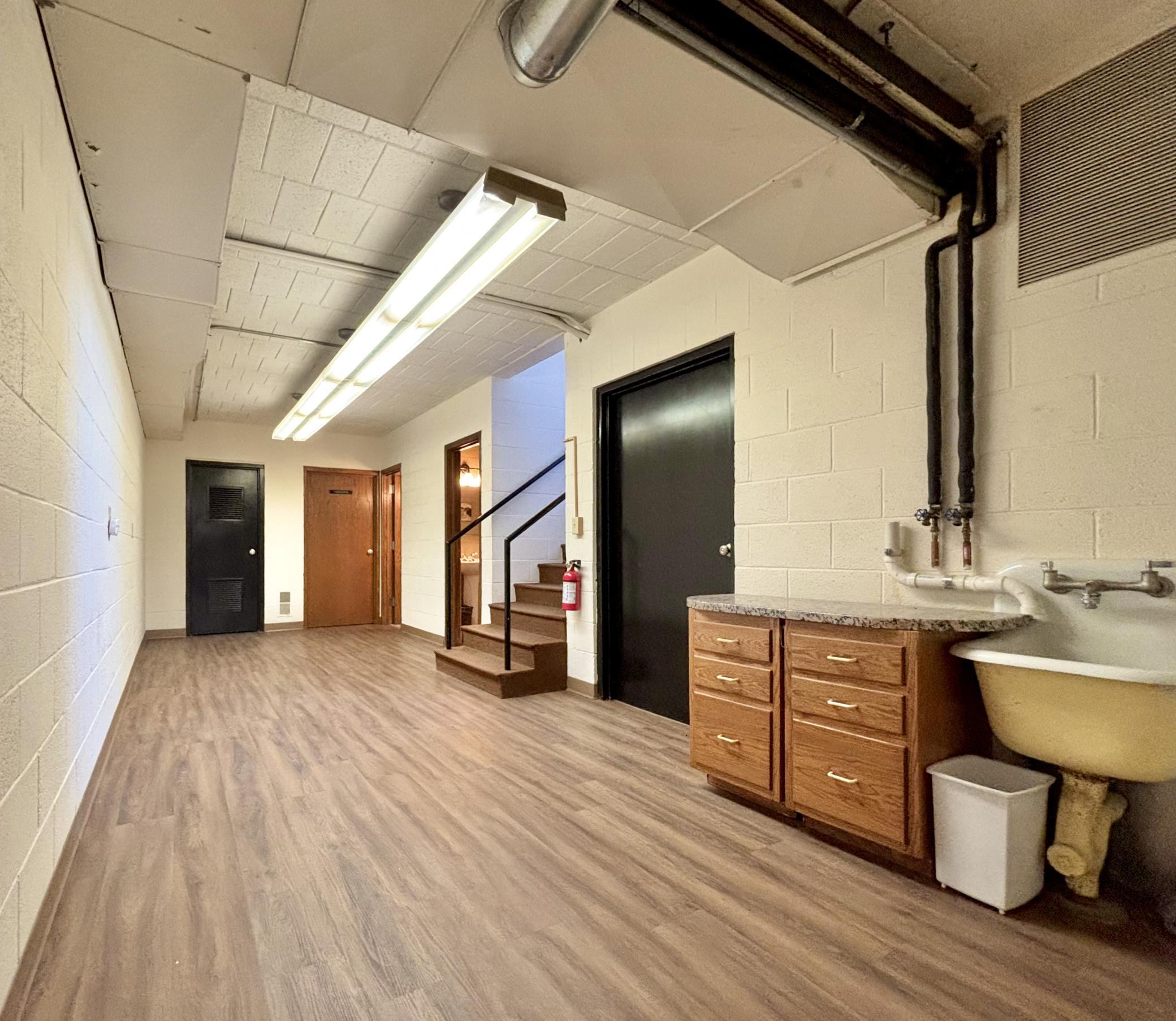 Downstairs has new flooring as well. The stairs going up lead to the reception area and then another stairs for your convenience behind this photo. Mechanical room behind the door to the right. In back storage to the left. RT is rentable space.