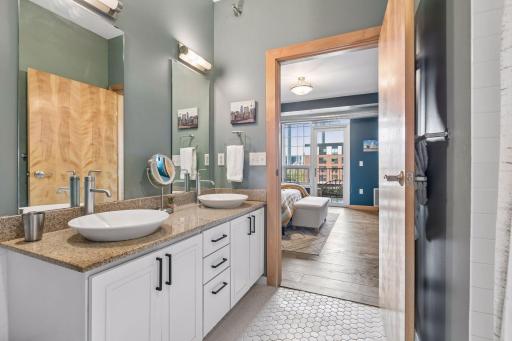 Spacious dual-sink vanity with vessel sinks, spacious countertop, large mirror, and modern fixtures.