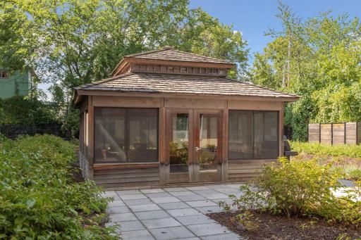 Charming screened gazebo in the landscaped condo courtyard, offering a comfortable shared space surrounded by mature greenery.
