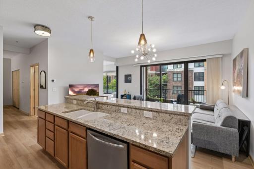 This is the kind of space that makes you want to linger. The living room and kitchen come together in one open, light-filled room, with high ceilings and walls of windows creating an airy, inviting feel.