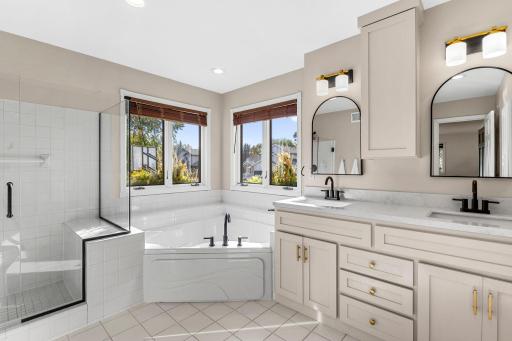 The primary bathroom features an updated tile shower and separate bathtub.