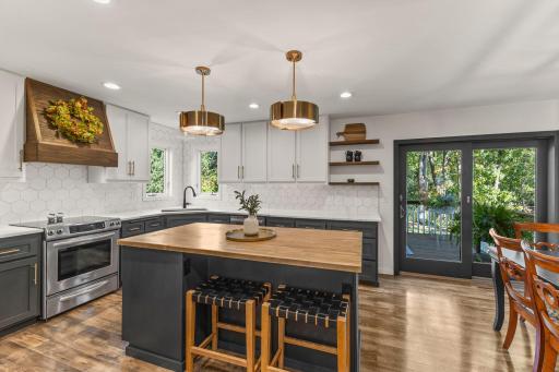 The kitchen has been updated with a modern backsplash and gold fixtures.
