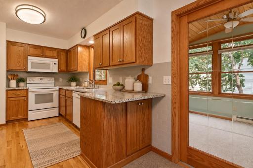 The kitchen is designed to make the most of the space, with granite countertops, generous cabinetry and a peninsula for extra prep spaceâall just steps from the four-season porch. (Virtually staged photo.)