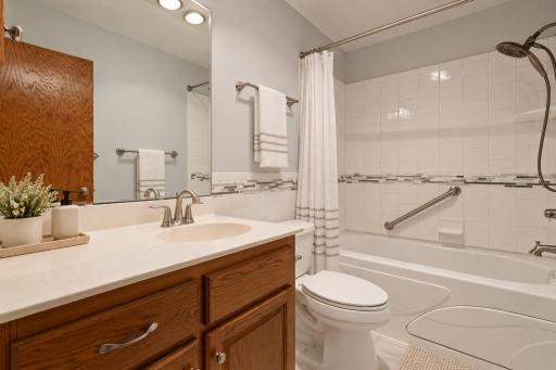 The lower-level full bath features a jetted tub with ceramic tile surround, offering a comfortable place to relax and unwind. (Virtually staged photo.)