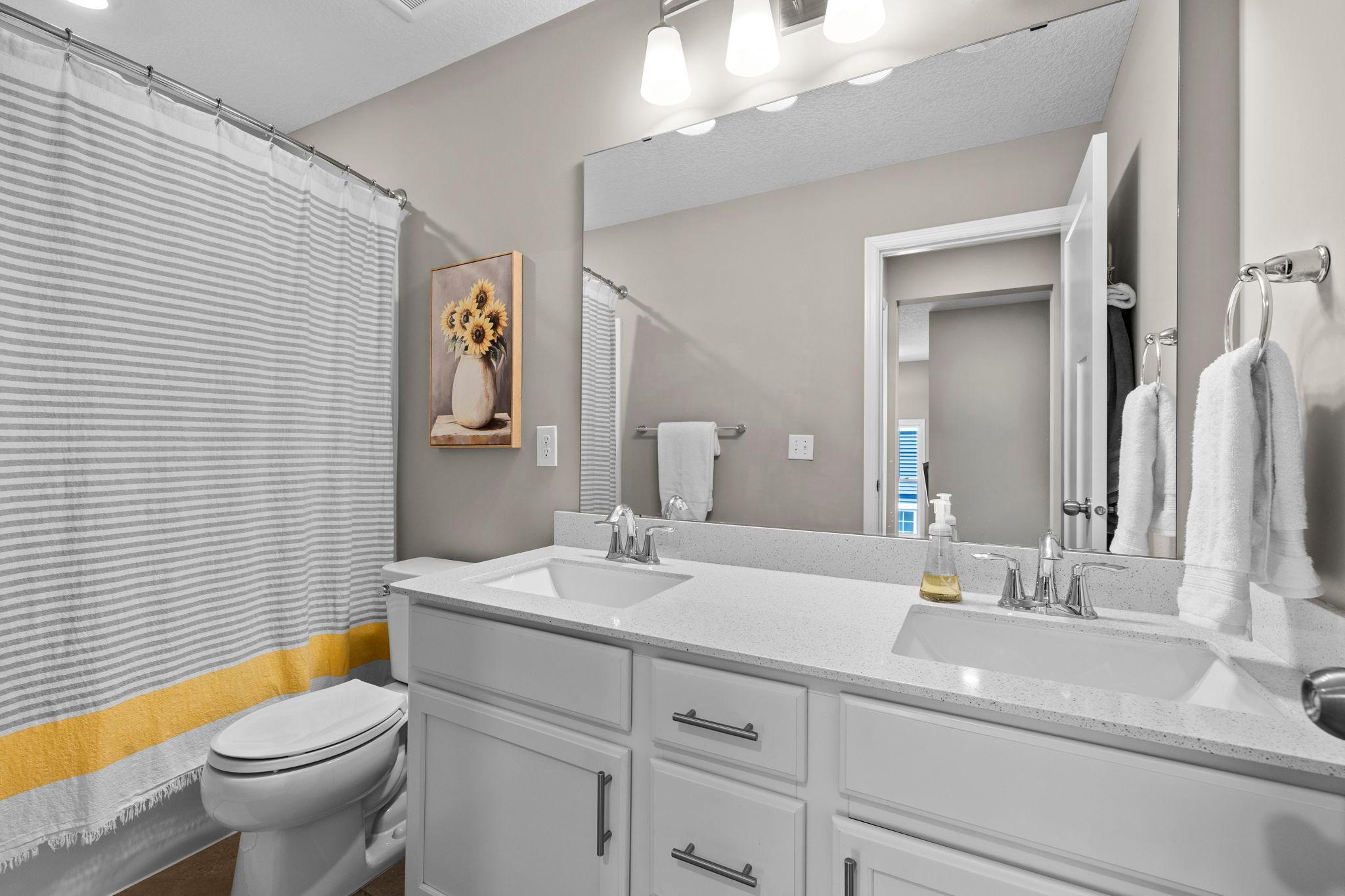 Upper level full bath with a double vanity and quartz countertops