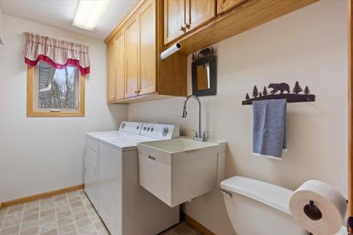 Laundry room right off garage entrance with tub and toilet