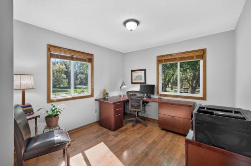 Second upper level bedroom with gleaming hardwood floors, neutral tones, and dual windows.